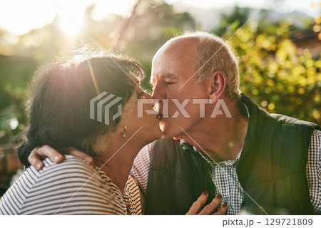 Kiss, love and senior couple in nature for love, date and affection during retirement holiday. Happy, care and interracial man and woman kissing with an embrace and smile in a park or garden Kiss, love and senior couple in nature for love, date and affection during retirement holiday. Happy, care and interracial man and woman kissing with an embrace and smile in a park or garden 129721809