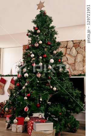 Christmas, tree with gifts and decorations for festive season celebration event in living room for magic holiday tradition. Xmas presents, Christmas tree ornaments and December winter vacation home Christmas, tree with gifts and decorations for festive season celebration event in living room for magic holiday tradition. Xmas presents, Christmas tree ornaments and December winter vacation home 129721951