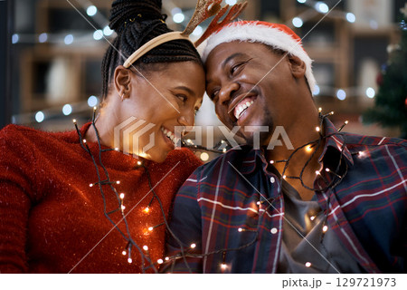 Couple, christmas celebration and festive holiday, lights and happy smile, hat and love together with home decoration. Black man, woman or happiness for xmas in house, celebrate or enjoy with partner Couple, christmas celebration and festive holiday, lights and happy smile, hat and love together with home decoration. Black man, woman or happiness for xmas in house, celebrate or enjoy with partner 129721973