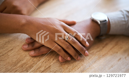 Couple, hands and support with love and trust zoom against wood table, hand touching with care and comfort. Helping hand, relax and commitment with relationship partnership and solidarity together. 129721977