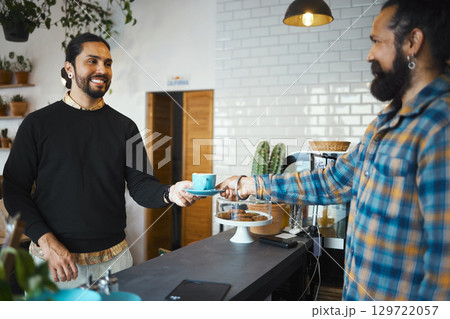 Coffee shop, customer services and people or barista in his small business startup, restaurant and food industry. Happy man with waiter, server or employee giving him an espresso in his cafe store 129722057
