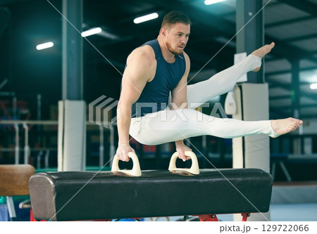 Gymnastics, practice and man training for a competition, performance and exercise in a gym. Focus, fitness and athlete gymnast doing a movement with balance, strength and artistic with flexibility Gymnastics, practice and man training for a competition, performance and exercise in a gym. Focus, fitness and athlete gymnast doing a movement with balance, strength and artistic with flexibility 129722066