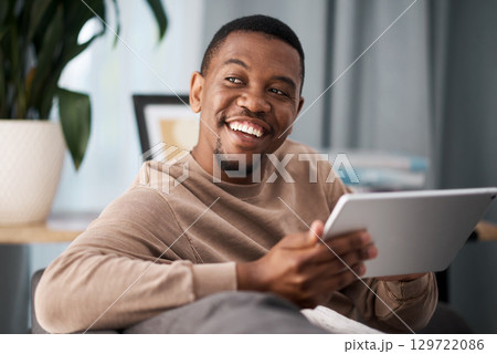 Black man, digital tablet and social media, living room home and streaming app, reading ebook or online shopping on technology. Happy guy, wifi connection and relax in lounge, wifi internet and ideas 129722086