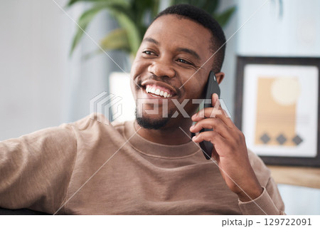 Black man, phone call and relax in home, house and living room, mobile communication and contact social network. Happy young african guy talking on smartphone, conversation and cellphone technology 129722091