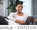 Black woman, happiness and tablet on sofa for communication, social media and online shopping or banking with home wifi connection. Female with technology for streaming, mobile app and social life 129722130