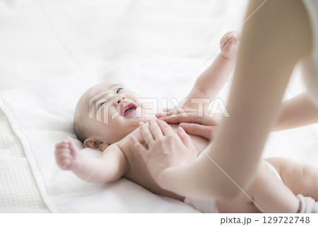 赤ちゃんのお世話をする若い母親 赤ちゃんのお世話をする若い母親 129722748