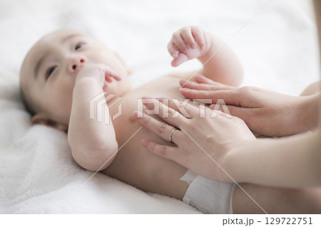 赤ちゃんのお世話をする若い母親 赤ちゃんのお世話をする若い母親 129722751