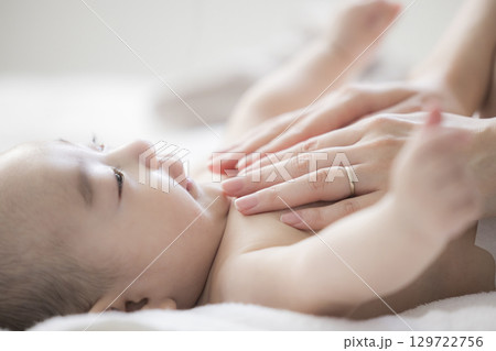 赤ちゃんのお世話をする若い母親 赤ちゃんのお世話をする若い母親 129722756