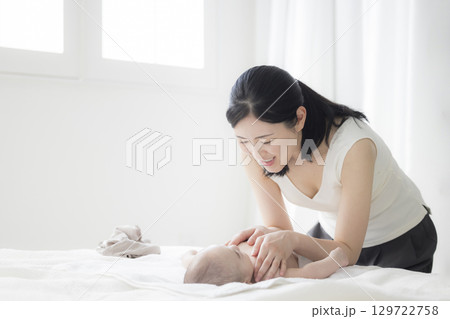 赤ちゃんのお世話をする若い母親 赤ちゃんのお世話をする若い母親 129722758