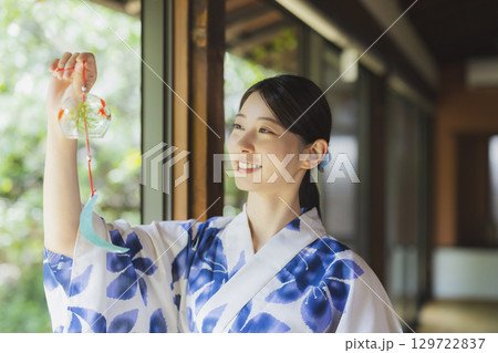 縁側で風鈴を持つ浴衣姿の女性 129722837