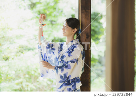 縁側で風鈴を持つ浴衣姿の女性 129722844