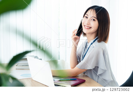 オフィスで通話する女性 オフィスで通話する女性 129723002