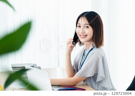 オフィスで通話する女性 129723004