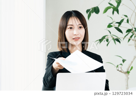 書類を手渡すビジネスウーマン 129723034