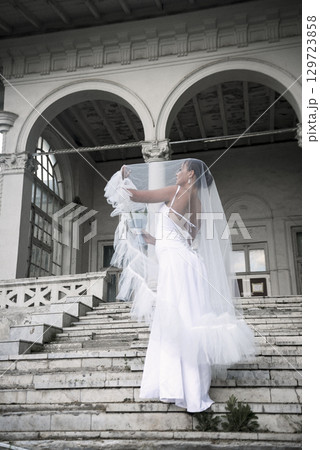 beautiful bride with a bouquet of flowers covered with a veil 129723858