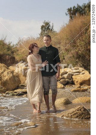 lovers and romantic newlyweds walk along the seashore 129724009
