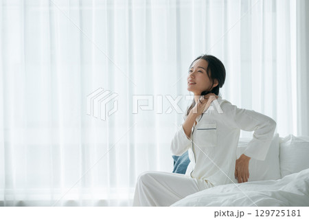 疲れた表情で起きる女性 129725181