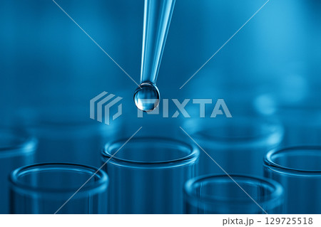 AI generated close up of a pipette releasing a clear droplet into glass test tubes with blue background conveying precision sterility and innovation in scientific research 129725518
