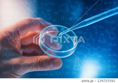AI generated close up of pipette dropping clear liquid into petri dish held by hand with transparent chemical formulas and molecular graphics in bright blue scientific background 129725592