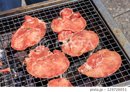 バーベキュー網の上で焼かれる食材 129726051