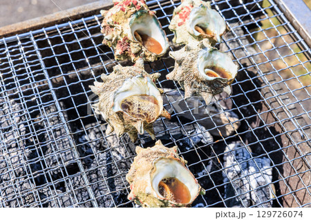 バーベキュー網の上で焼かれる食材 バーベキュー網の上で焼かれる食材 129726074
