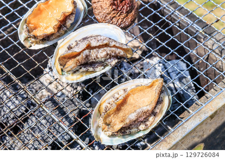 バーベキュー網の上で焼かれる食材 129726084