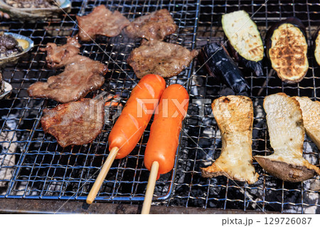 バーベキュー網の上で焼かれる食材 バーベキュー網の上で焼かれる食材 129726087