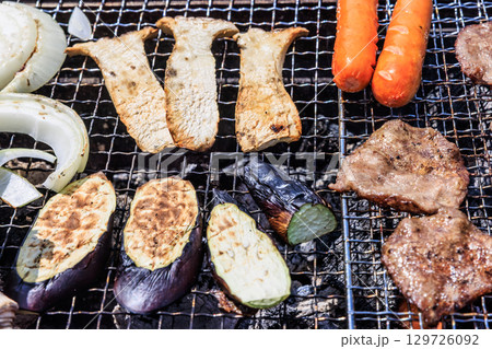 バーベキュー網の上で焼かれる食材 バーベキュー網の上で焼かれる食材 129726092