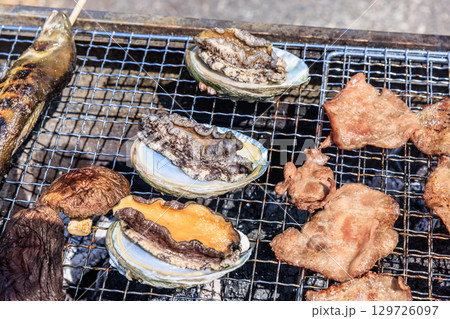 バーベキュー網の上で焼かれる食材 129726097