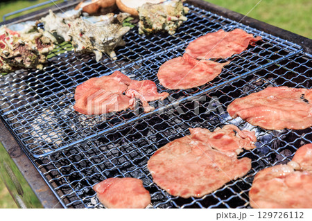 バーベキュー網の上で焼かれる食材 バーベキュー網の上で焼かれる食材 129726112