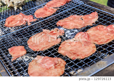 バーベキュー網の上で焼かれる食材 バーベキュー網の上で焼かれる食材 129726113