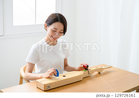 ブンネ楽器を弾く女性 129726161