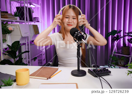 Podcast host recording professional audio for streaming broadcast and digital content creation in modern studio 129726239