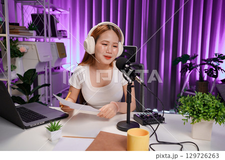 Podcast host recording professional audio for streaming broadcast and digital content creation in modern studio 129726263