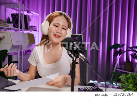 Podcast host recording professional audio for streaming broadcast and digital content creation in modern studio 129726264