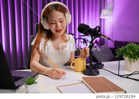Podcast host recording professional audio for streaming broadcast and digital content creation in modern studio 129726284