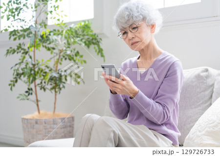 スマートフォンを操作しているシニア女性 スマートフォンを操作しているシニア女性 129726733