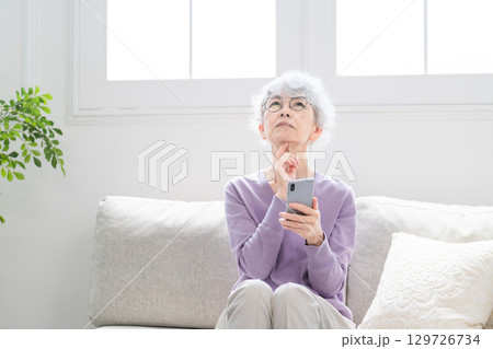 スマートフォンを操作しているシニア女性 スマートフォンを操作しているシニア女性 129726734