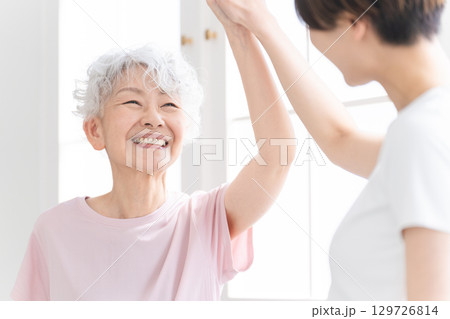 ヨガをする若い女性とシニア女性　健康イメージ 129726814