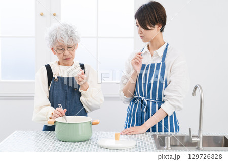 キッチンに立つ若い女性とシニア女性 料理イメージ キッチンに立つ若い女性とシニア女性 料理イメージ 129726828