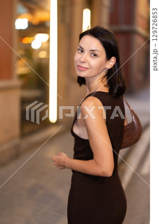 Young woman stands beside crosswalk on street with old buildings in Barcelona Young woman stands beside crosswalk on street with old buildings in Barcelona 129726853