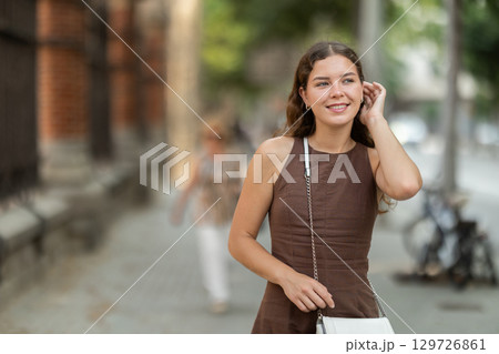 Young female tourist dressing in dress enjoying walk near columns of architectural complex of Hospital de la Santa Creu i Sant Pau in Barcelona 129726861