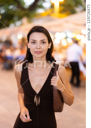 In evening, smiling girl walks around old city district Barceloneta, in vicinage of Citadel Park In evening, smiling girl walks around old city district Barceloneta, in vicinage of Citadel Park 129726875
