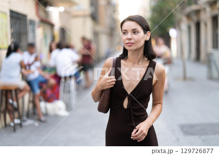 Woman walks along narrow street between buildings of 19th century 129726877
