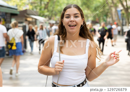Cheerful young girl walking along summer La Rambla in Barcelona 129726879