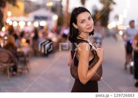 Young woman walking on a lively promenade of Barceloneta Young woman walking on a lively promenade of Barceloneta 129726883
