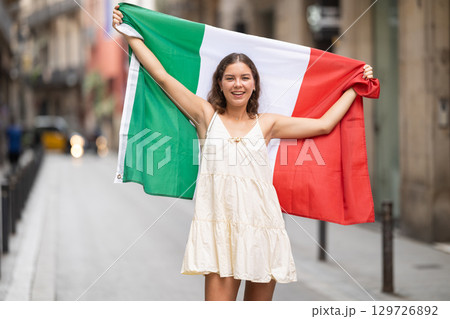Portrait of woman with Italy flag on street of summer city Portrait of woman with Italy flag on street of summer city 129726892