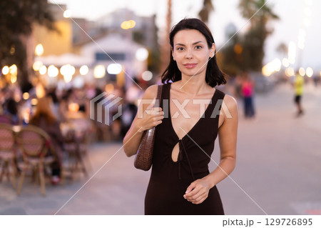 Smiling girl walks around old city district Barceloneta, pedestrian promenade embankment. Smiling girl walks around old city district Barceloneta, pedestrian promenade embankment. 129726895