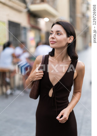Young woman walks along narrow street in old Barcelona 129726908