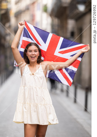 Young woman with UK flag on city street 129726992
